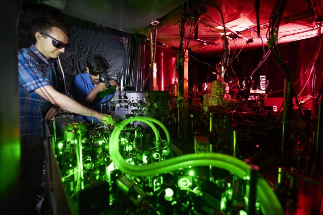 Scientists working on a laser tabletop in ne of the quantum research laboratories at LMU München. 